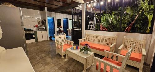 a room with a table and chairs and a kitchen at Entre Cantos - Hospedaje Rural in Ibagué