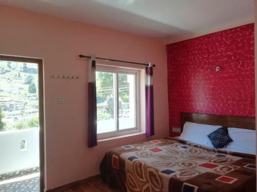 um quarto com uma cama com uma parede vermelha em queenhill homestay2 em Ooty