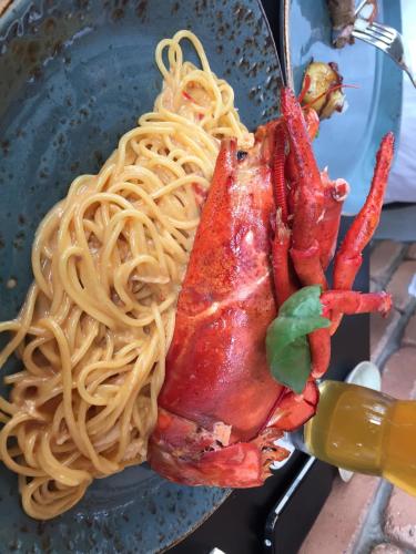 a plate of pasta with a lobster on a fork at Olympic Residence Deluxe Apartments in Limassol