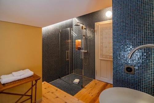 a bathroom with a shower with blue tiles at Villa Klainguti in Pontresina