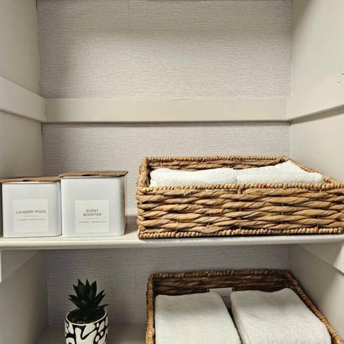 two baskets on a shelf with towels and a plant at Atlantic City Bungalow Retreat in Atlantic City