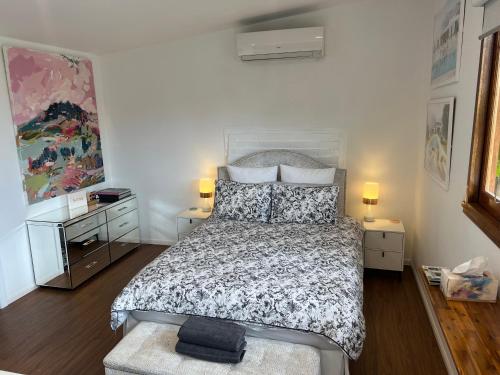1 dormitorio con 1 cama, 2 mesitas de noche y 2 lámparas en Gold Coast Retreat, en Ormeau