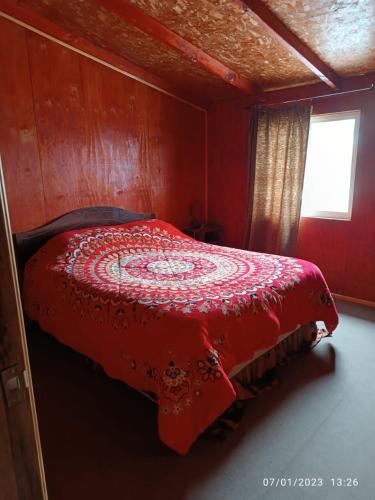 czerwone łóżko w pokoju z oknem w obiekcie Casa en Puerto Montt w mieście Puerto Montt