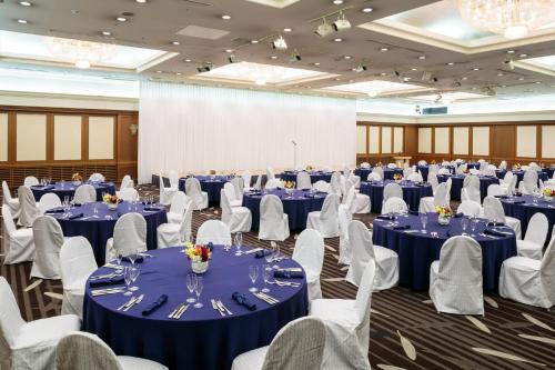 a large banquet hall with blue tables and white chairs at ANA Crowne Plaza Sapporo, an IHG Hotel in Sapporo