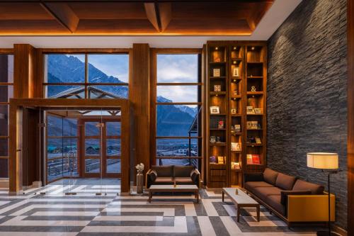 a living room with a view of the mountains at Four Points by Sheraton Sonmarg Resort in Sonāmarg