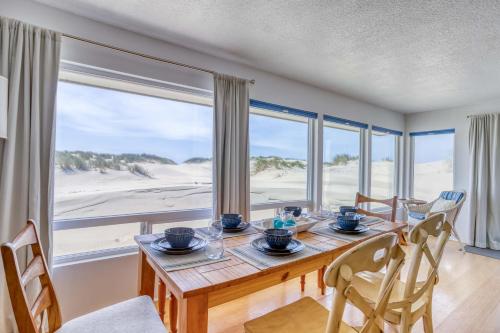 a dining room with a table and chairs and a large window at Sand and Sky in Bayshore
