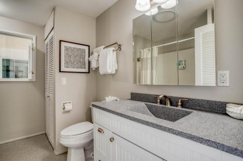 a bathroom with a sink and a toilet and a mirror at Sand and Sky in Bayshore