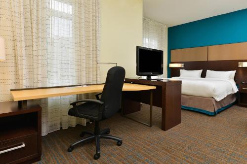 a hotel room with a desk with a bed and a computer at Residence Inn by Marriott Champaign in Champaign