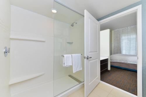 a bathroom with a shower and a glass door at Residence Inn by Marriott Champaign in Champaign
