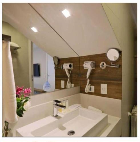 a bathroom with a sink and a mirror at Hotel Resort Carpe Diem 2Q in Campos do Jordão