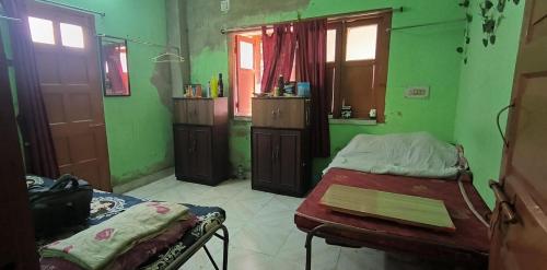 a room with two beds in a green room at Ladies pg in Kolkata