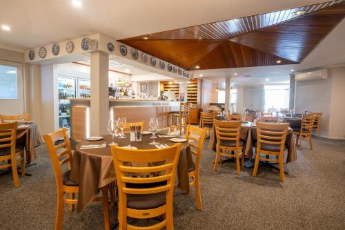 uma sala de jantar com mesas e cadeiras num restaurante em Posthouse Motor Lodge em Goulburn