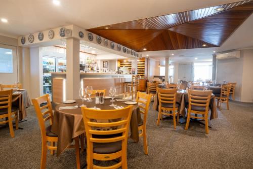 un comedor con mesas y sillas en un restaurante en Posthouse Motor Lodge, en Goulburn