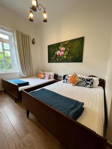 a room with two beds and a window at De Daisy Villa Homestay in Da Lat