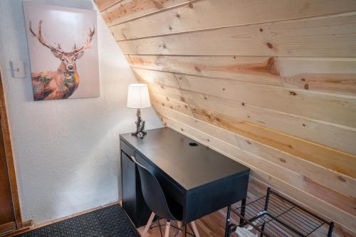 a desk with a lamp next to a wooden wall at A-Frame Cabin - Mountain Views, Deck, Pet Friendly in Idaho Springs