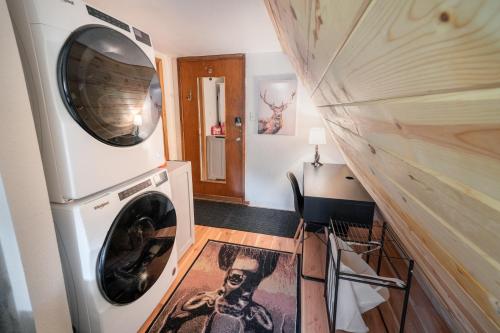 a laundry room with a washer and dryer next to a wall at A-Frame Cabin - Mountain Views, Deck, Pet Friendly in Idaho Springs