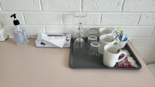 a tray with cups and mugs on a counter at KooWeeRup Motel in Koo-Wee-Rup