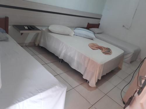 a bedroom with a white bed with a towel on it at Hotel Fontes do Iguaçu in Foz do Iguaçu