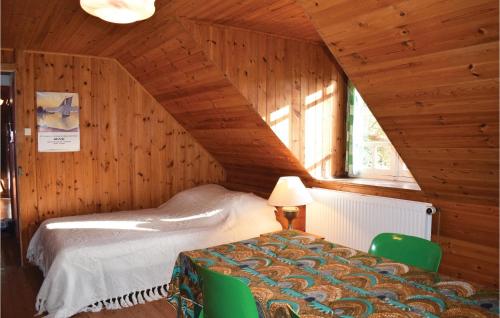 1 dormitorio con 1 cama en un ático de madera en Cozy Home In Plourivo With Kitchen, en Lanleff