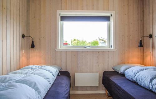 a bedroom with two beds and a window at Nice Home In Haderslev With 3 Bedrooms And Wifi in Årøsund