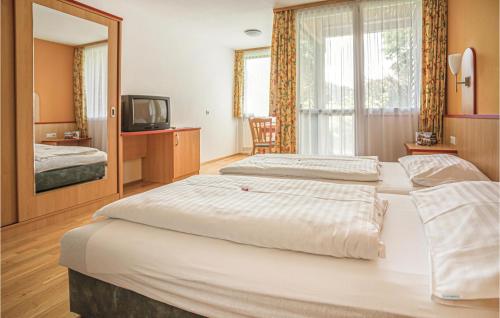 ザンクト・ローレンツェン・オプ・ムーラウにあるAwesome Apartment In St,georgen Am Kreischb, With Sauna, Wifi And Indoor Swimming Poolのベッド2台とテレビが備わるホテルルームです。