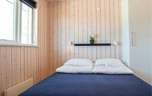 FlovtにあるAmazing Home In Haderslev With 3 Bedrooms, Sauna And Wifiの木製の壁の客室で、ベッド1台(枕2つ付)