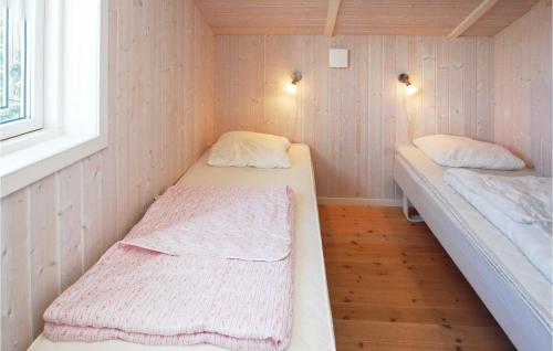 FlovtにあるAmazing Home In Haderslev With 5 Bedrooms, Sauna And Wifiのベッド2台と窓が備わる小さな客室です。