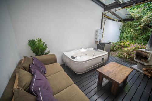a living room with a couch and a tub on a deck at Vistas del Conde in Heredia