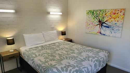 1 dormitorio con 1 cama con una pintura en la pared en KooWeeRup Motel, en Koo-Wee-Rup
