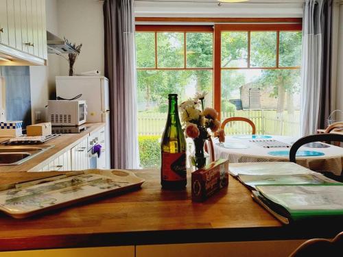 - une cuisine avec une bouteille de vin sur une table en bois dans l'établissement Gîte de Charme avec Jardin, Equipé pour Familles et Bébés, à 15km de Dunkerque et 3km de Bergues - FR-1-510-170, à Quaëdypre