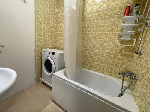 a bathroom with a washing machine next to a washer at Apartment Lana in Tivat