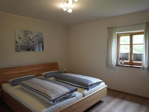 2 Betten in einem Schlafzimmer mit Fenster in der Unterkunft Ferienwohnung Am Feldbach in Bad Aibling