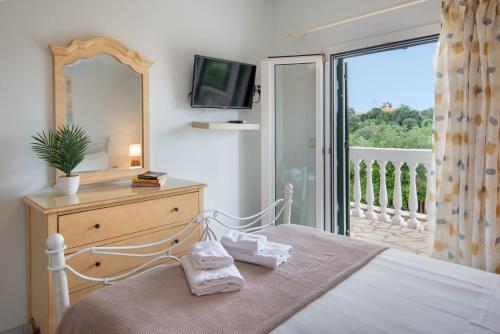 a bedroom with a bed and a television and a balcony at Militsa House in Gaios