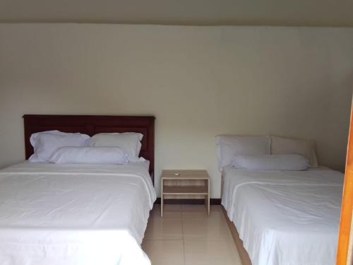 dos camas sentadas una al lado de la otra en una habitación en Pesona Room and restaurant, en Labuan Bajo