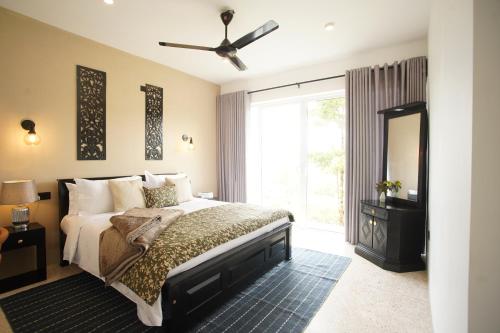 sypialnia z łóżkiem i dużym oknem w obiekcie Thumpers Cottage w mieście Kalawana