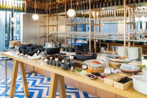 a restaurant with a buffet line with food and wine glasses at W Osaka in Osaka