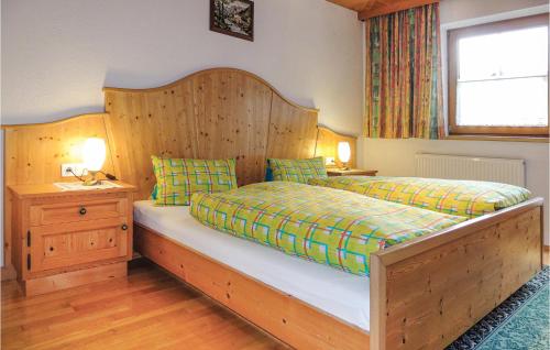 a bedroom with a large bed with a wooden headboard at Awesome Apartment In Aschau With 3 Bedrooms And Internet in Aschau