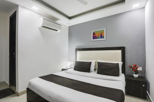 ein Schlafzimmer mit einem großen Bett in einem Zimmer in der Unterkunft Super OYO Hotel Mannat Near Lotus Temple in Neu-Delhi