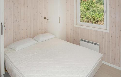 Cama blanca en habitación con ventana en Awesome Home In Augustenborg With 3 Bedrooms And Sauna en Asserballeskov