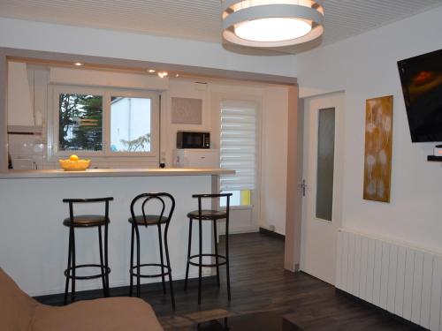 une cuisine avec trois tabourets de bar dans une pièce dans l'établissement Maison rénovée avec jardin, proche plage, idéale famille, WiFi inclus - FR-1-323-535, à Saint-Hilaire-de-Riez