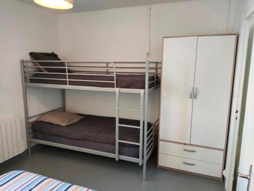 une chambre avec deux lits superposés et un placard dans l'établissement Maison rénovée avec jardin, proche plage, idéale famille, WiFi inclus - FR-1-323-535, à Saint-Hilaire-de-Riez