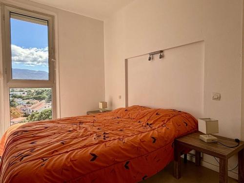 um quarto com uma cama e uma grande janela em Appartement Argelès-sur-Mer, 2 pièces, 4 personnes - FR-1-225-814 em Argelès-sur-Mer