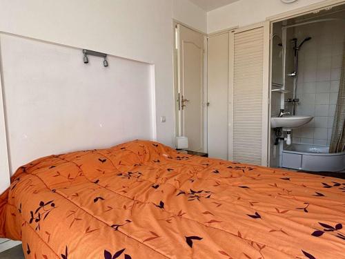 um quarto com uma cama laranja com pássaros em Appartement Argelès-sur-Mer, 2 pièces, 4 personnes - FR-1-225-814 em Argelès-sur-Mer