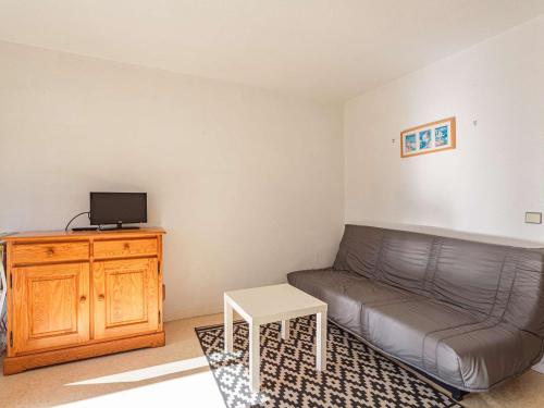 un petit salon avec un canapé et une table dans l'établissement Appartement à Anglet : proche commerces, plages, et nature, avec parking et loggia - FR-1-3-606, à Anglet