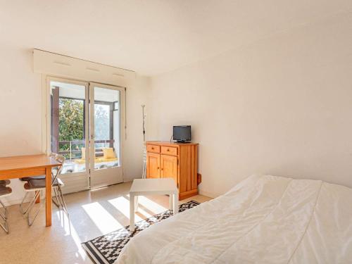 une chambre avec un lit, un bureau et une fenêtre dans l'établissement Appartement à Anglet : proche commerces, plages, et nature, avec parking et loggia - FR-1-3-606, à Anglet