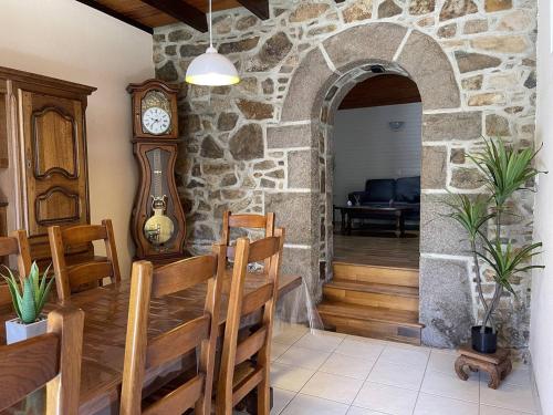 Cette chambre est dotée d'un mur en pierre avec une table et une horloge. dans l'établissement Maison à Ploumanac'h avec jardin et WIFI, proche plage - FR-1-368-419, à Perros-Guirec