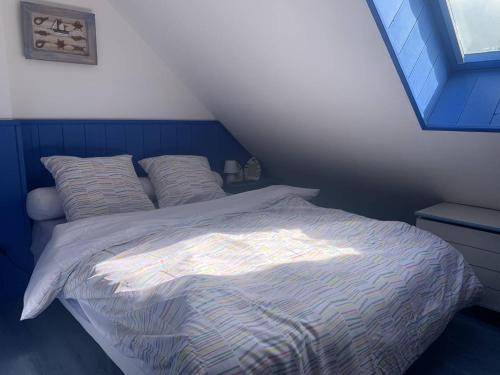 une chambre avec un lit avec une couette bleue et blanche dans l'établissement Duplex avec Jardin Privé pour 4 Pers. à 400m de la Plage - Merville-Franceville - FR-1-465-110, à Merville-Franceville-Plage