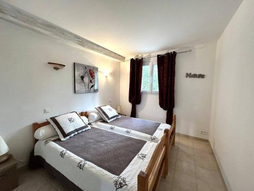 een slaapkamer met 2 bedden en een raam bij Maison L'Isle-sur-la-Sorgue, 3 pièces, 4 personnes - FR-1-767-20 in LʼIsle-sur-la-Sorgue