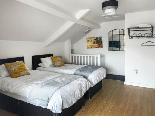 two beds in a room with white walls and wood floors at Highmead - Uk46951 in Blackwood