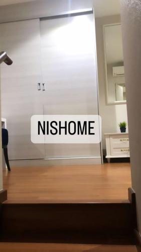 een bord waarop staat nitzhome op een muur in een kamer bij Homestay Murah Icity Shah Alam Duplex in Shah Alam